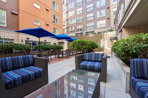 a patio with chairs and tables and umbrellas